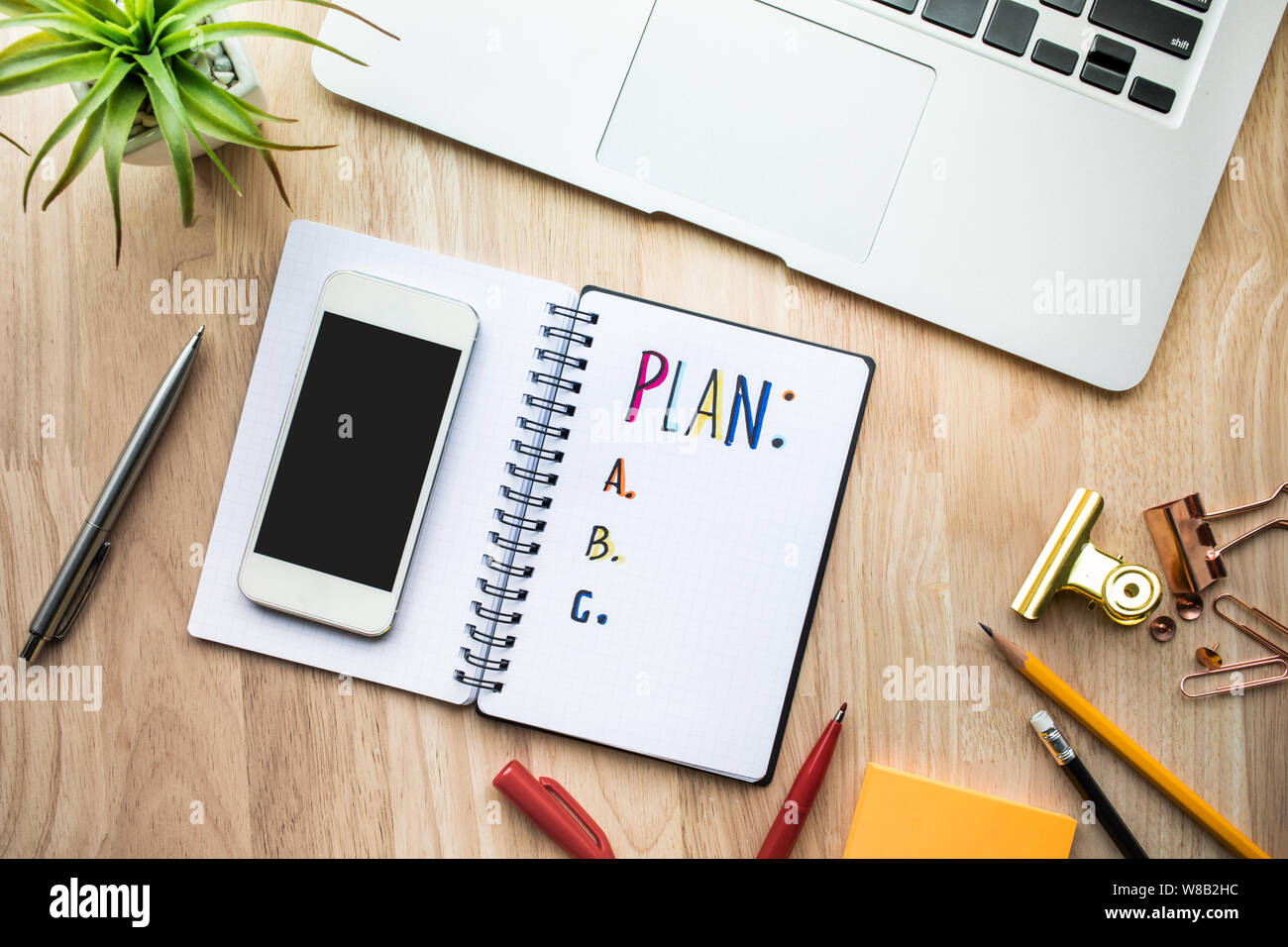 Business plan concepts with notepad paper on wooden table and supplies.flat lay design Stock Photo