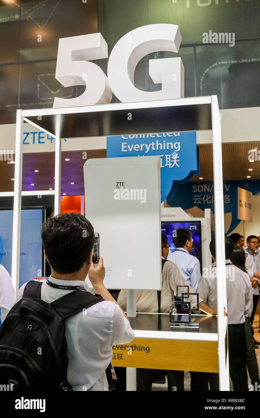 A visitor takes photos at the stand of ZTE 5G networks during the 2016 Mobile World Congress (MWC) in Shanghai, China, 29 June 2016.   Given the capac Stock Photo