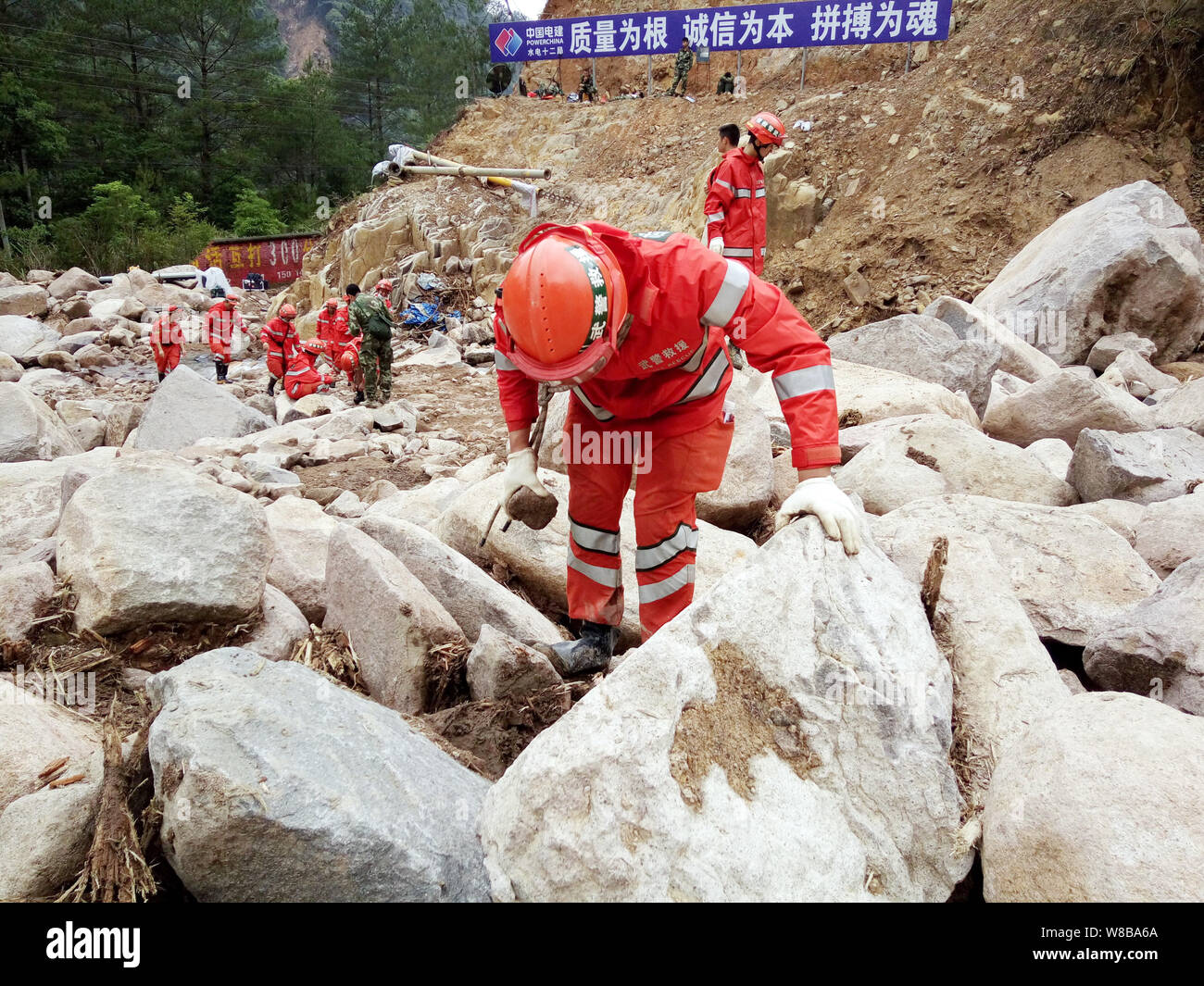 Chinese rescuers search for victims and survivors in debris of the massive landslide at a construction site in Chitan village, Taining county, Sanming Stock Photo