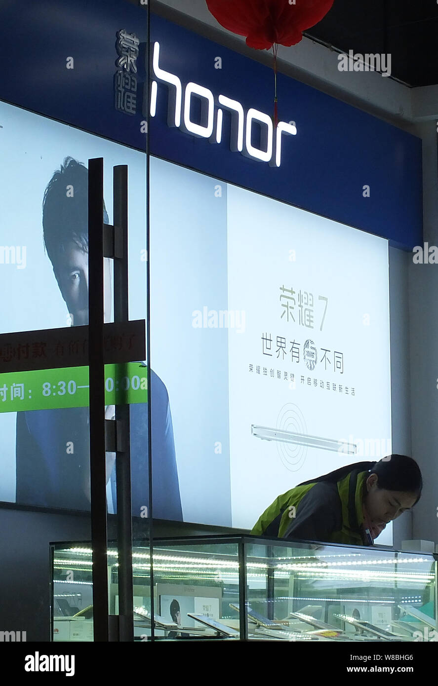 File A Chinese Employee Is Seen In Front Of An Advertisement For