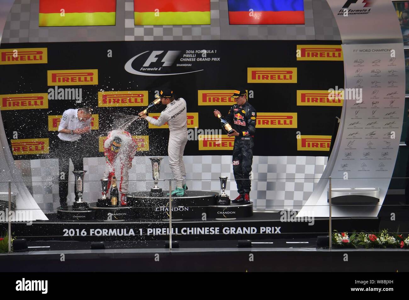 Mecedes driver Nico Rosberg of Germany, second right, celebrates by spraying champagne on Ferrari driver Sebastian Vettel of Germany, second left, nex Stock Photo