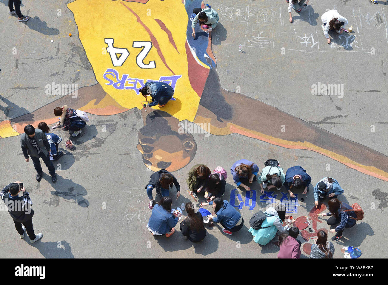 Chinese students put final touches on the giant portrait painting of NBA superstar Kobe Bryant to mark his retirement at Shenyang Sport University in Stock Photo