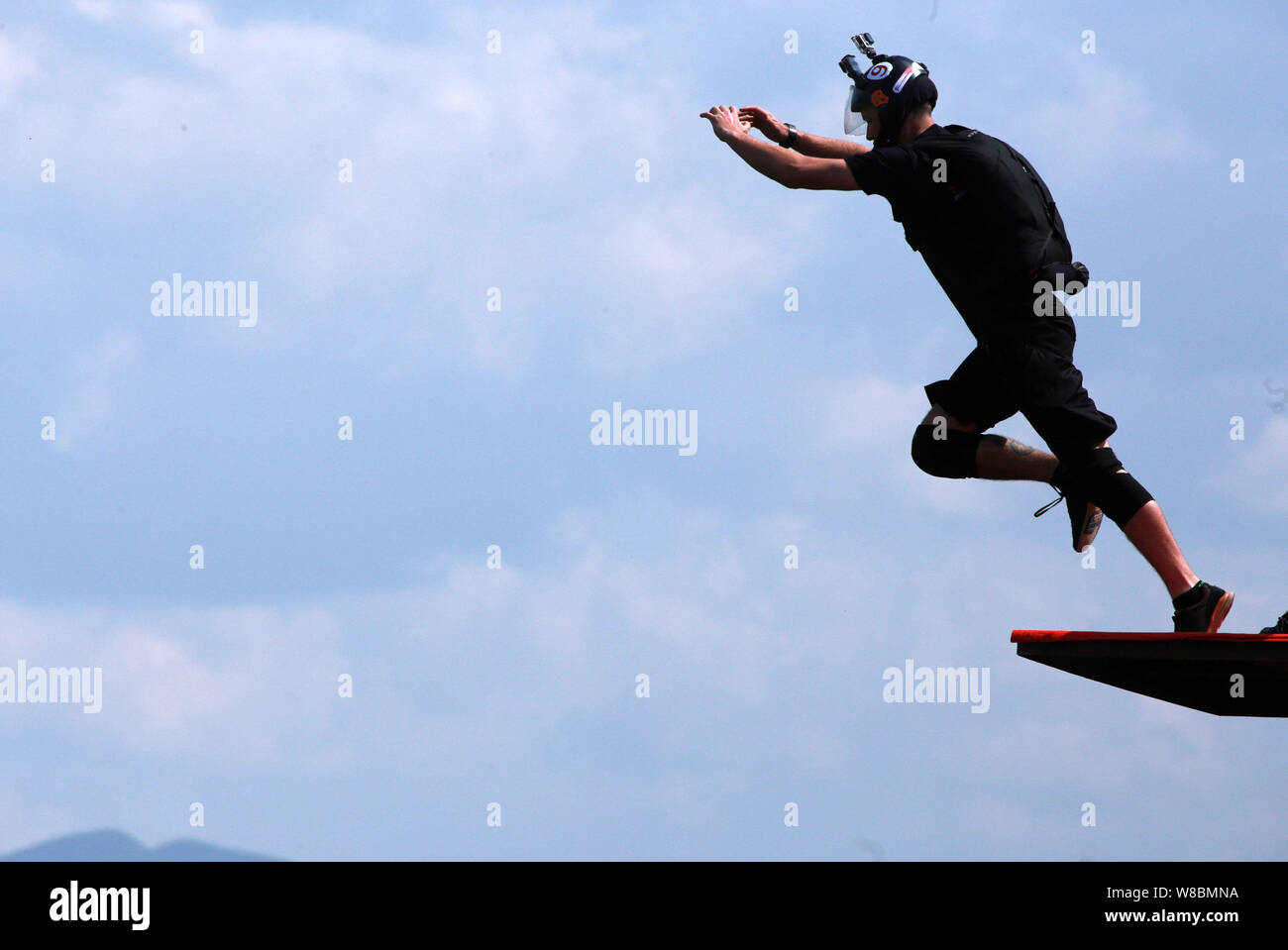 A contestant jumps off the glass cantilever bridge on the cliff during the 2016 World Low-Altitude Parachute Jump in Longgang scenic area in Yunyang c Stock Photo