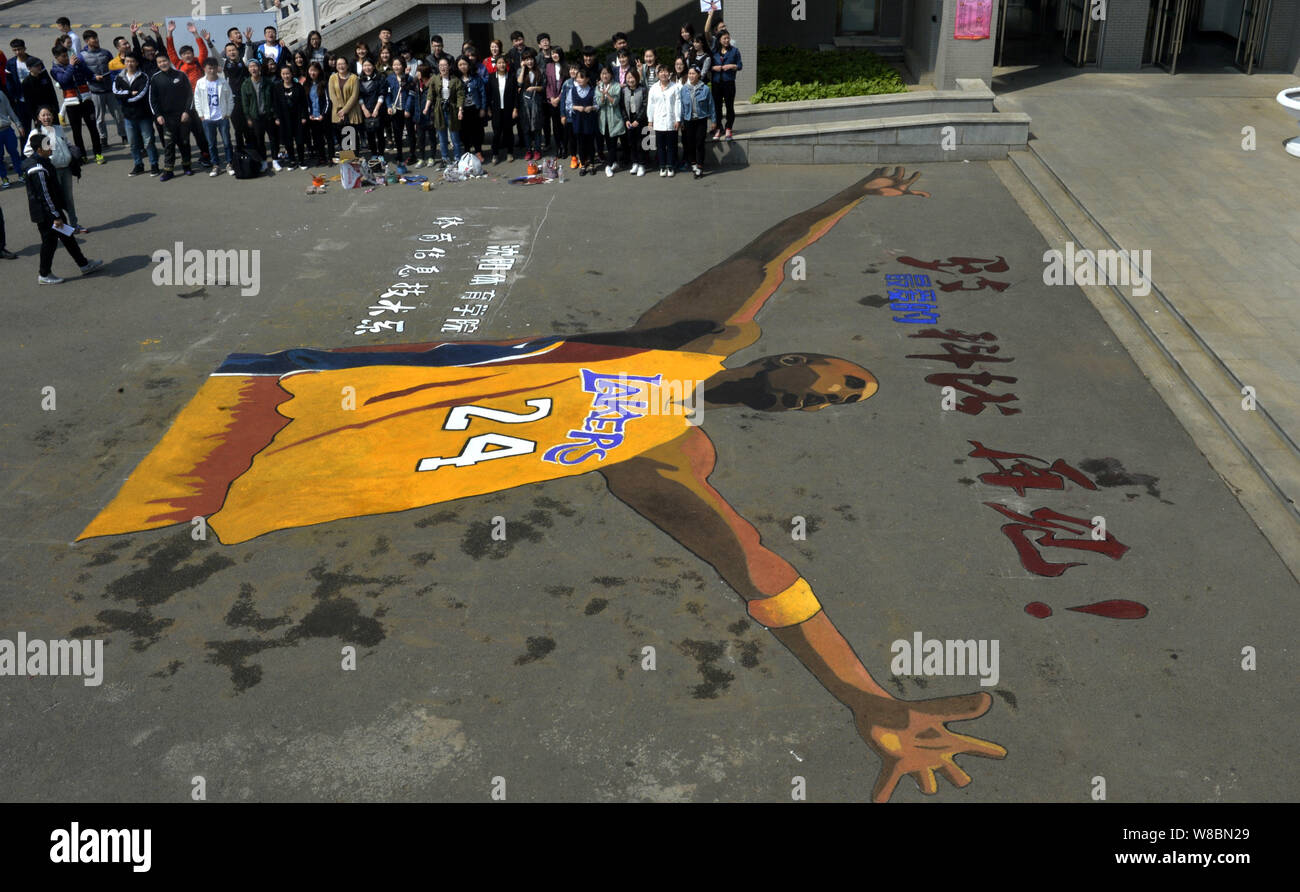 Chinese students look at the giant portrait painting of NBA superstar Kobe Bryant to mark his retirement at Shenyang Sport University in Shenyang city Stock Photo