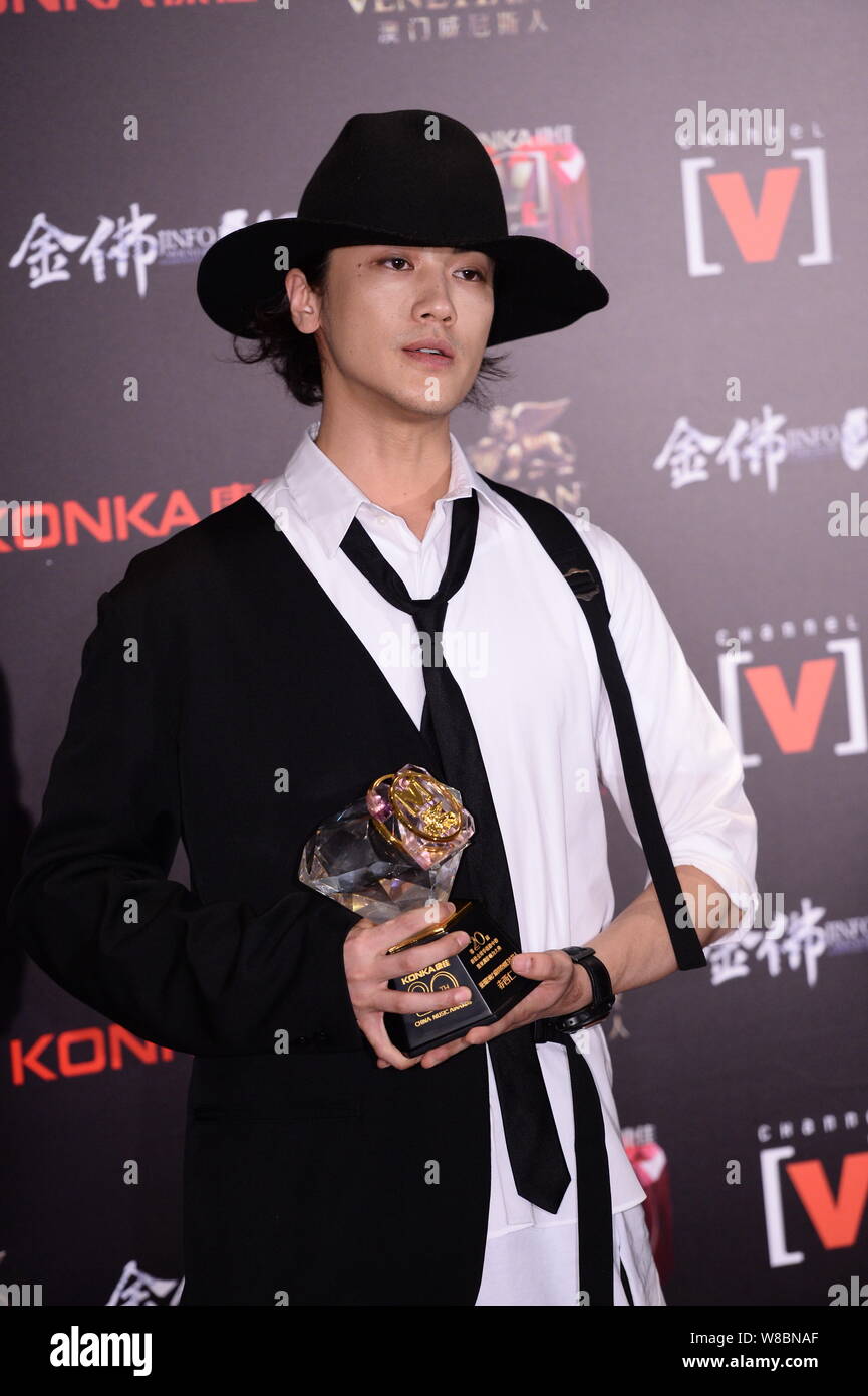 Japanese singer Jin Akanishi poses with his trophy after the