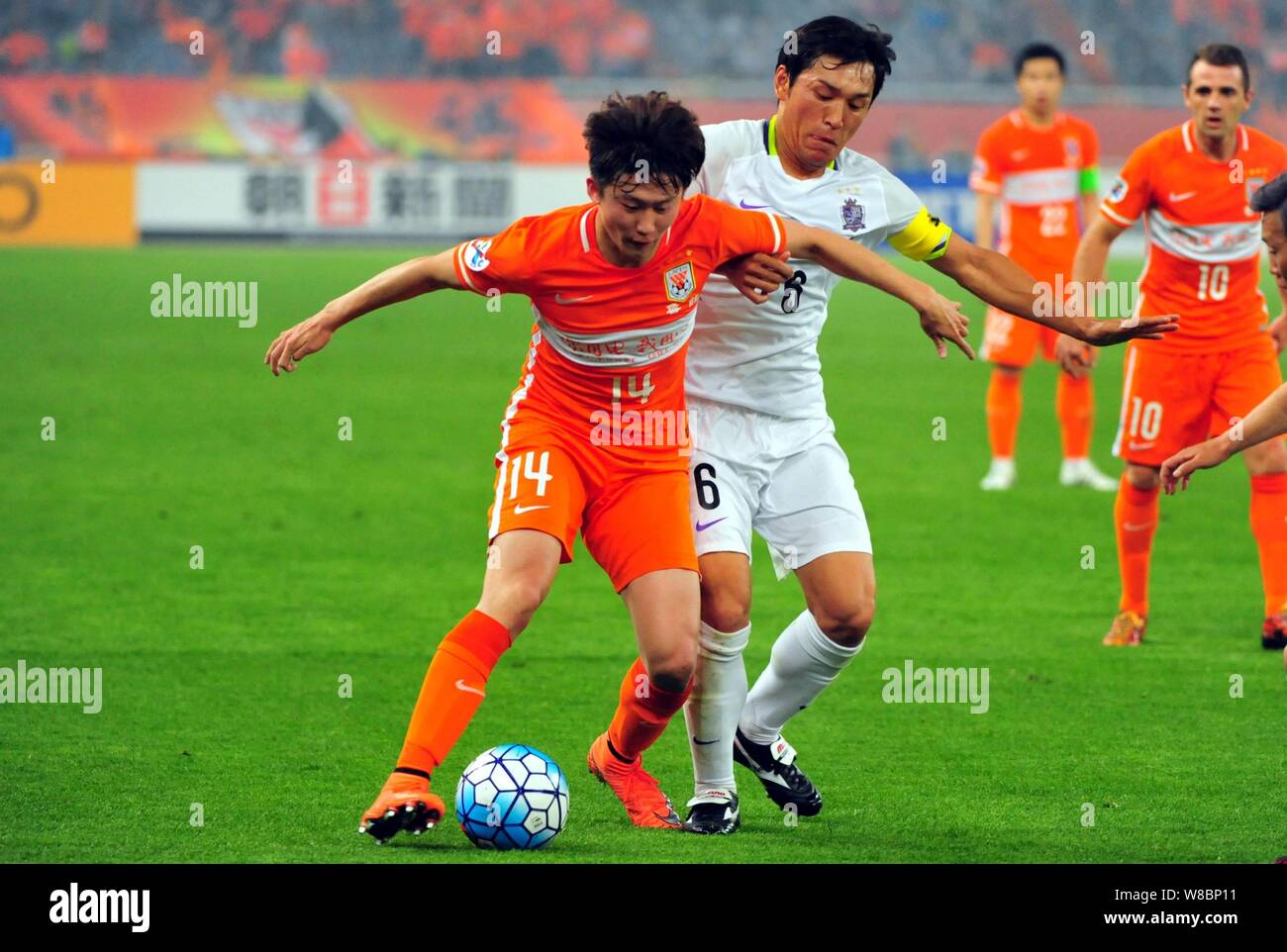Wang Tong of China's Shandong Luneng, left, challenges Toshihiro Aoyama of Japan's Sanfrecce Hiroshima in their Group F match during the 2016 AFC Cham Stock Photo