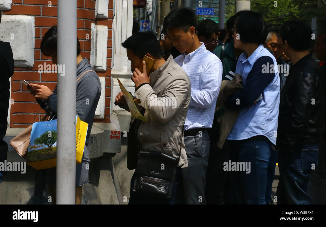 Applicants queue up to purchase the bidding document for vehicle license plate auctions in front of Shanghai International Commodity Auction Co., Ltd. Stock Photo