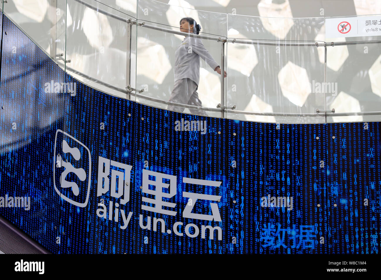 FILE--A woman walks past an electronic display showing an advertisement of  Aliyun.com, the online cloud computing unit of Alibaba Group, in Shenzhen  Stock Photo - Alamy