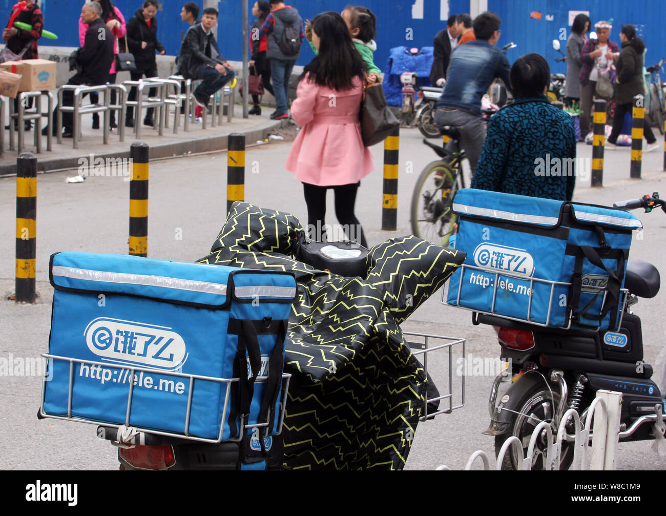 FILEPedestrians walk past electric bikes of deliverymen of Chinese