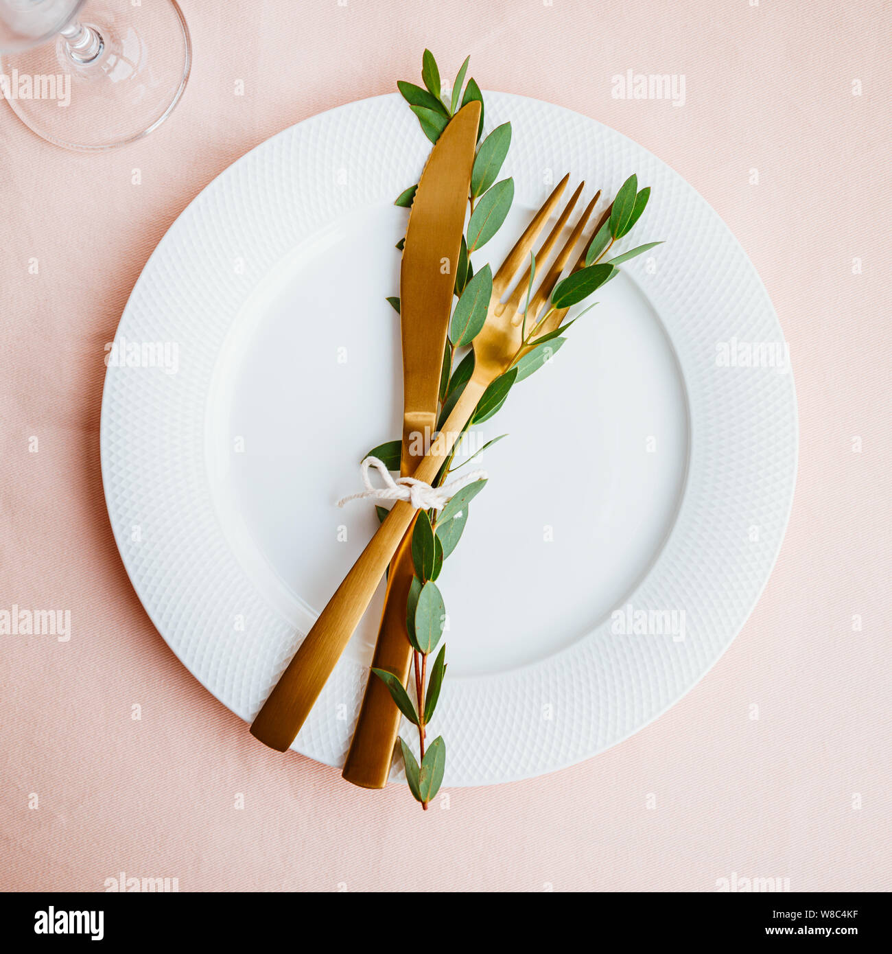 Festive table setting for celebrate event with decorated golden cutlery on a white table. Top view, flat lay. Stock Photo