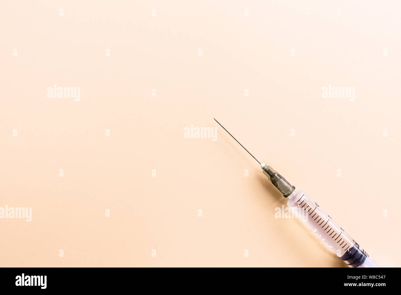 Pastel Injection Medical syringe on pastel orange background, give an injection and be ...