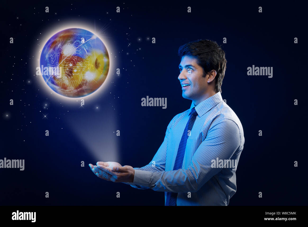 Businessman with a glowing globe of circuits Stock Photo