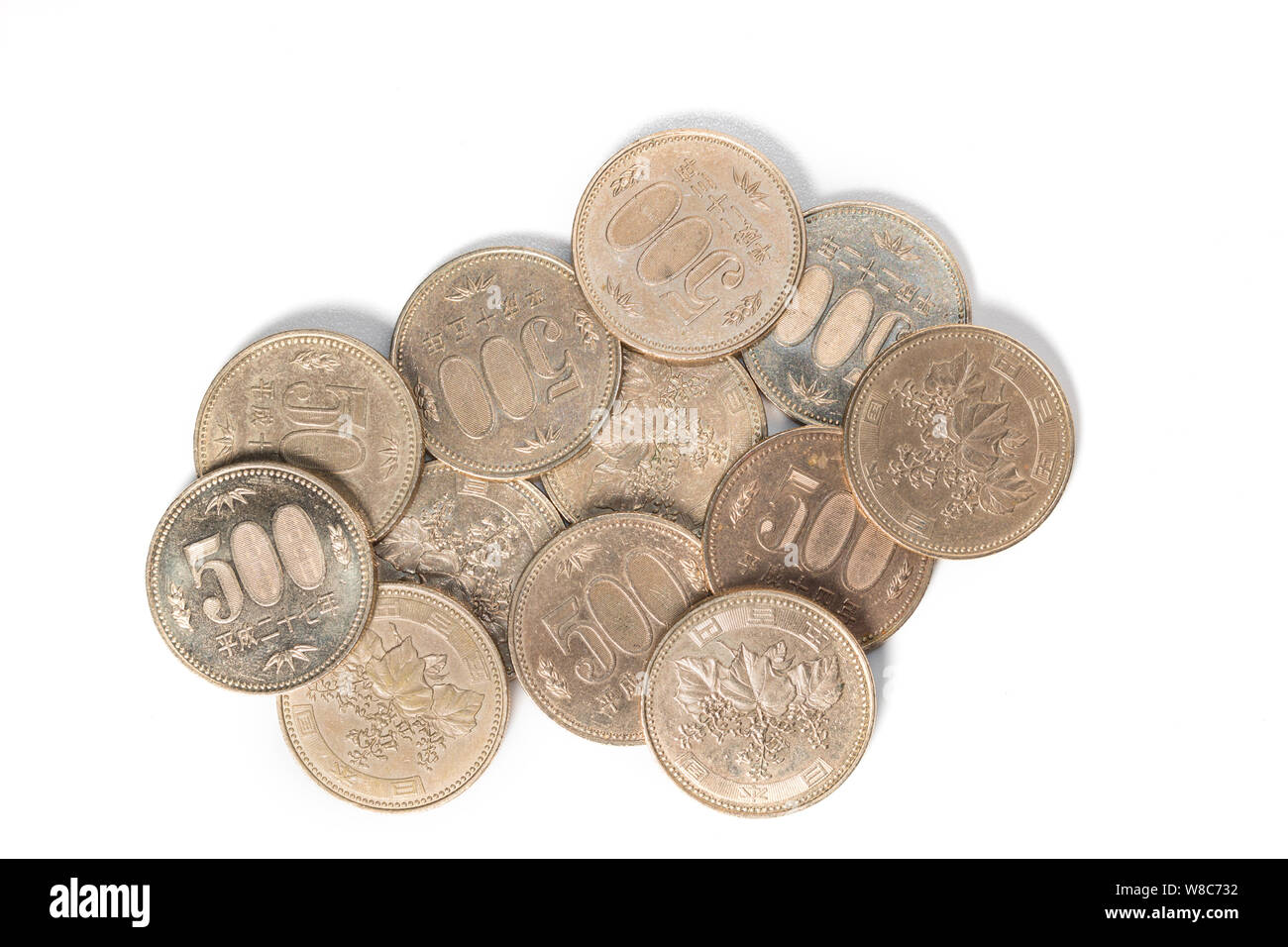 Pile of 500 yen coins japanese money, close up on white background. Stock Photo