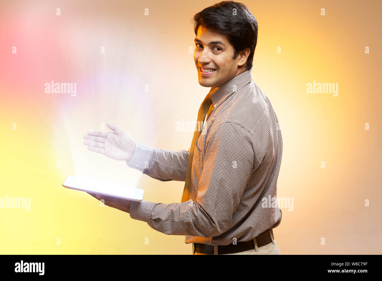 Businessman using a digital tablet and lights streaming from it Stock Photo