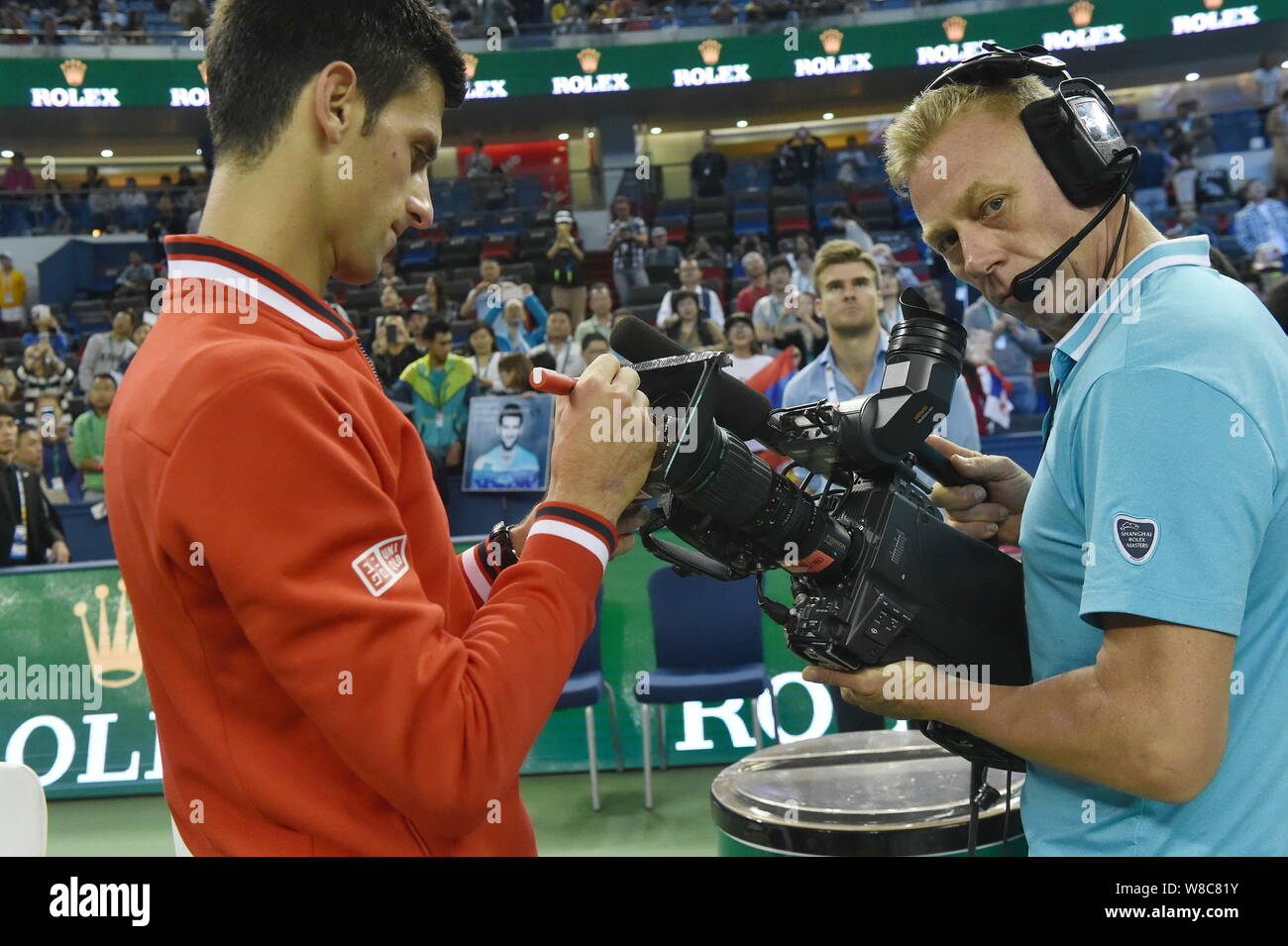 Novak Djokovic of Serbia, left, writes the Chinese character "Fu", meaning  "Blessing" in English, on the lens of a video camera after defeating Felici  Stock Photo - Alamy
