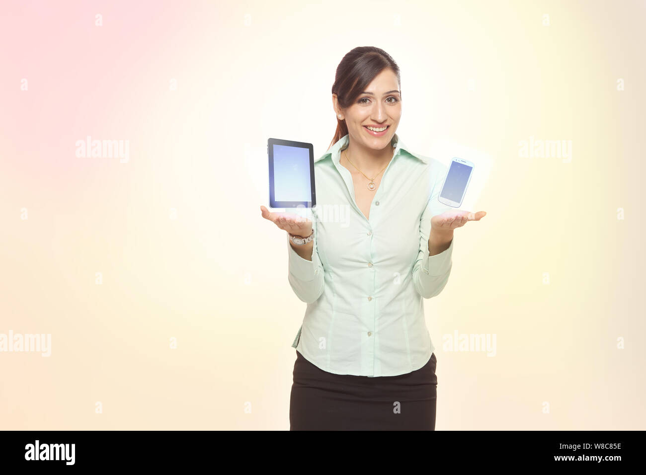 Businesswoman comparing smart phone with digital tablet Stock Photo