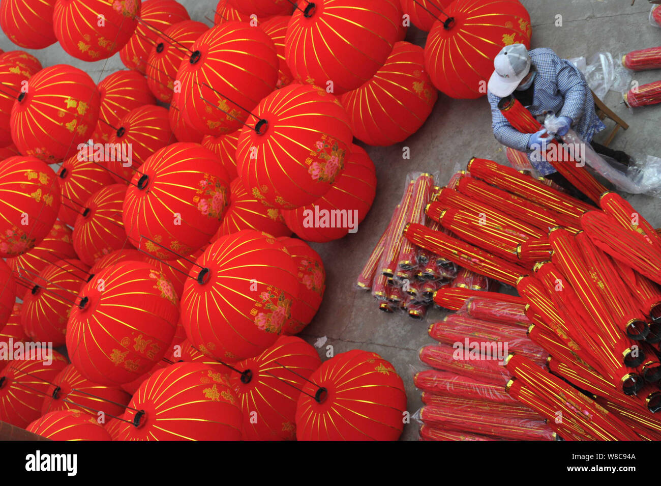 A Chinese worker packages lanterns after finishing production in a lantern workshop in Yuncheng city, north China's Shanxi province, 20 December 2015. Stock Photo