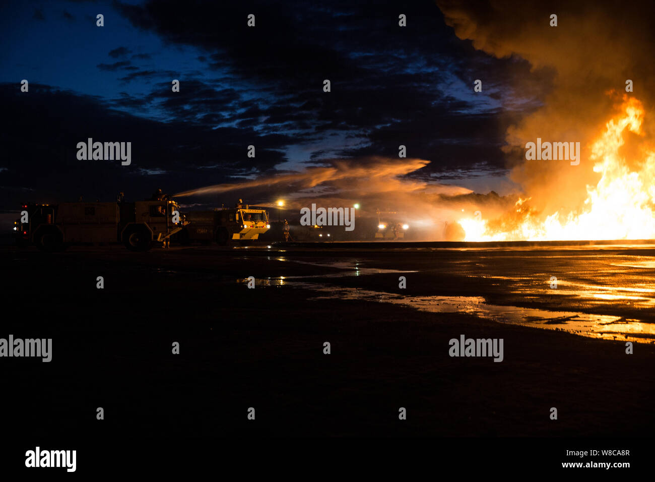 U.S. Marines with Aircraft Rescue and Firefighting (ARFF), assigned to Headquarters and Headquarters Squadron, conduct a controlled fuel burn drill at Marine Corps Air Station Cherry Point, North Carolina, July 31, 2019. The training exercise replicated the kind of fires they may encounter in the line of duty and helped familiarize the Marines with the vehicles, gear, and rescue equipment needed to safely and efficiently extinguish fuel fires. The ARFF Marines used hand-line attacks as well as P-19 fire trucks to contain the flames. (U.S. Marine Corps photo by Lance Cpl. Michael Neuenhoff). Stock Photo