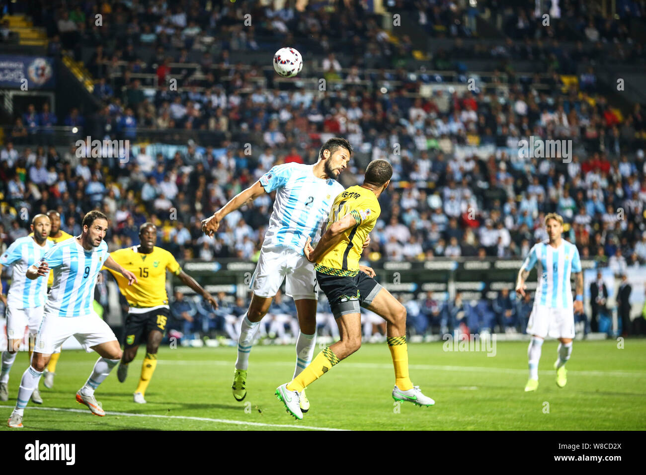 Argentina's Ezequiel Garay, center left, challenges Jamaica's Michael Hector, center right, during a Copa America Group B soccer match at the Sausalit Stock Photo