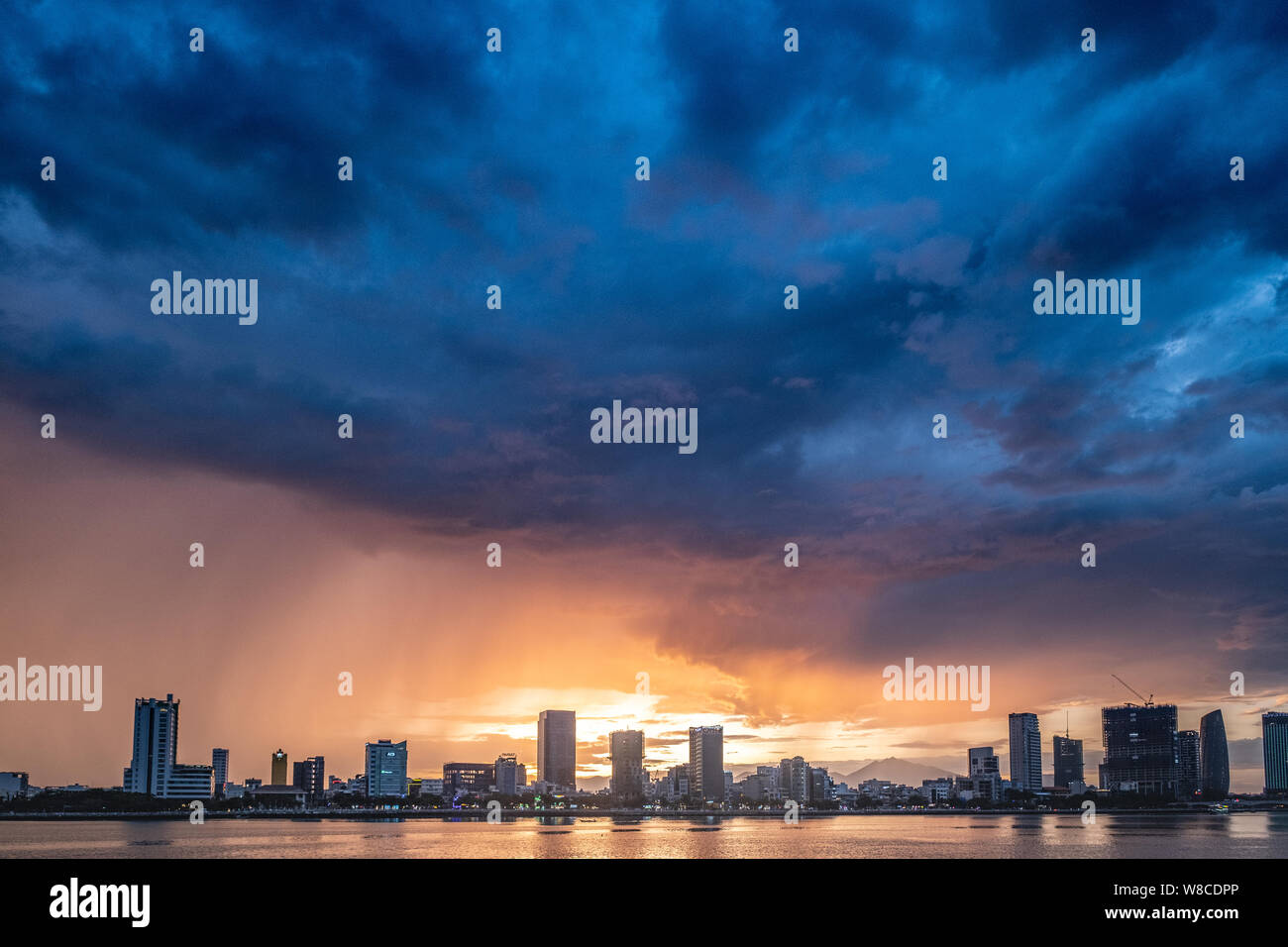 Beautiful sunset over  Đà Nẵng city in central Vietnam with heavy clouds above Stock Photo