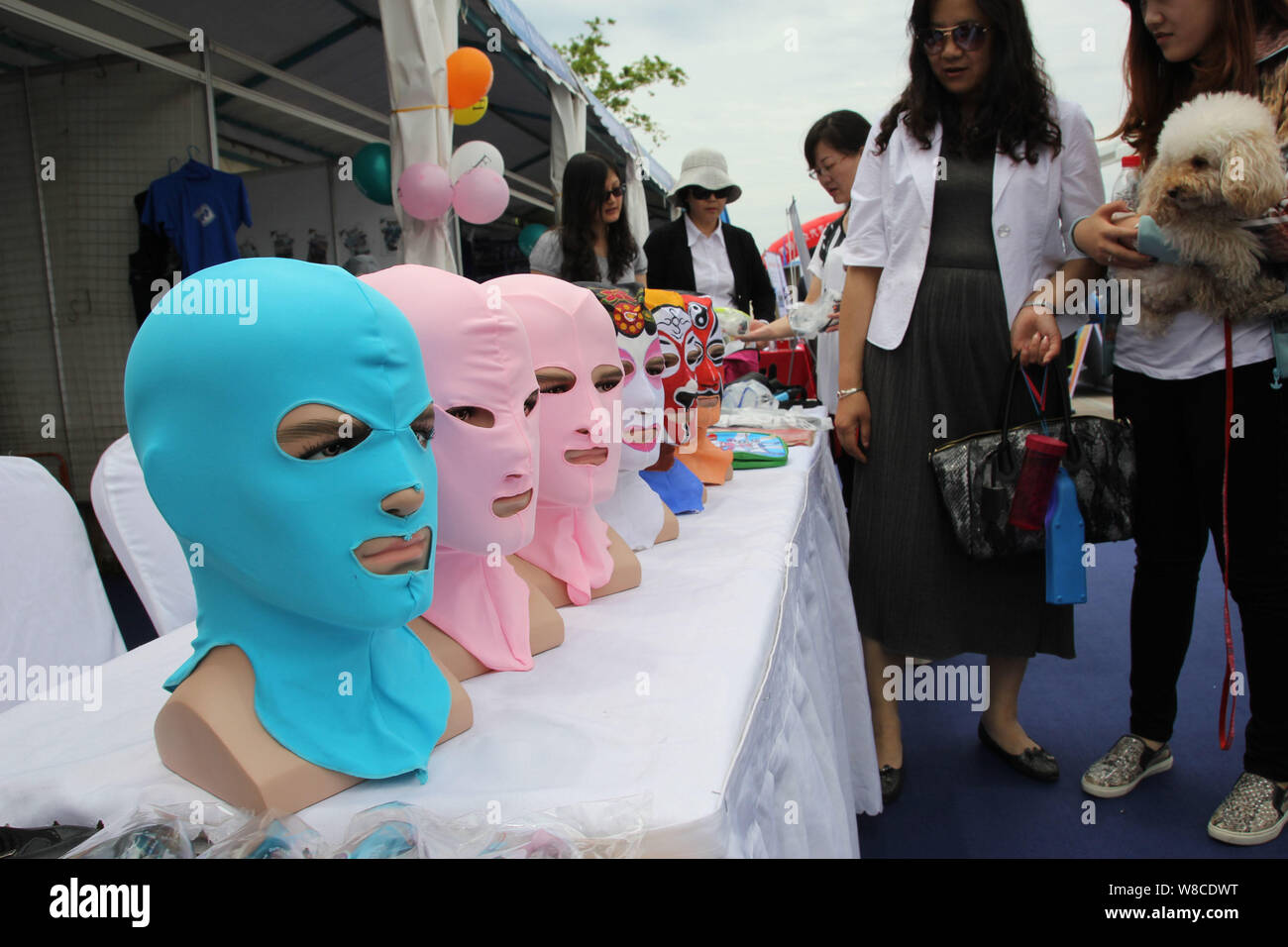 Visitors look at facekini masks by Chinese facekini designer Zhang