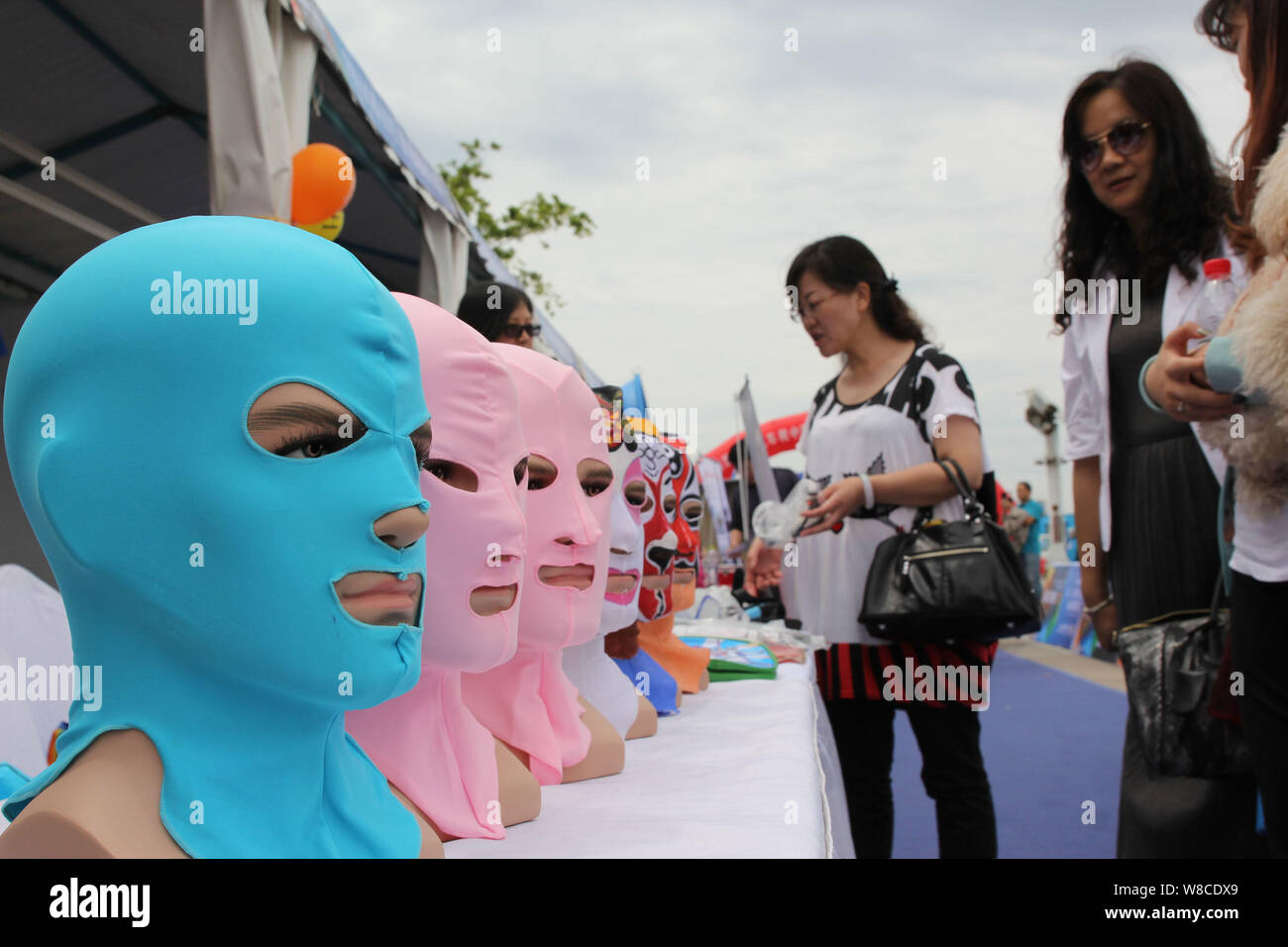 Visitors look at facekini masks by Chinese facekini designer Zhang