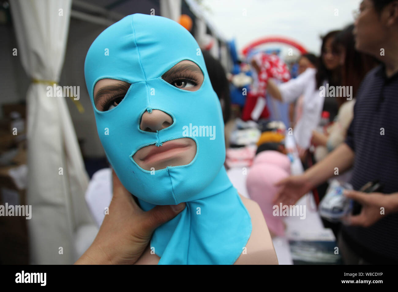Visitors look at facekini masks by Chinese facekini designer Zhang