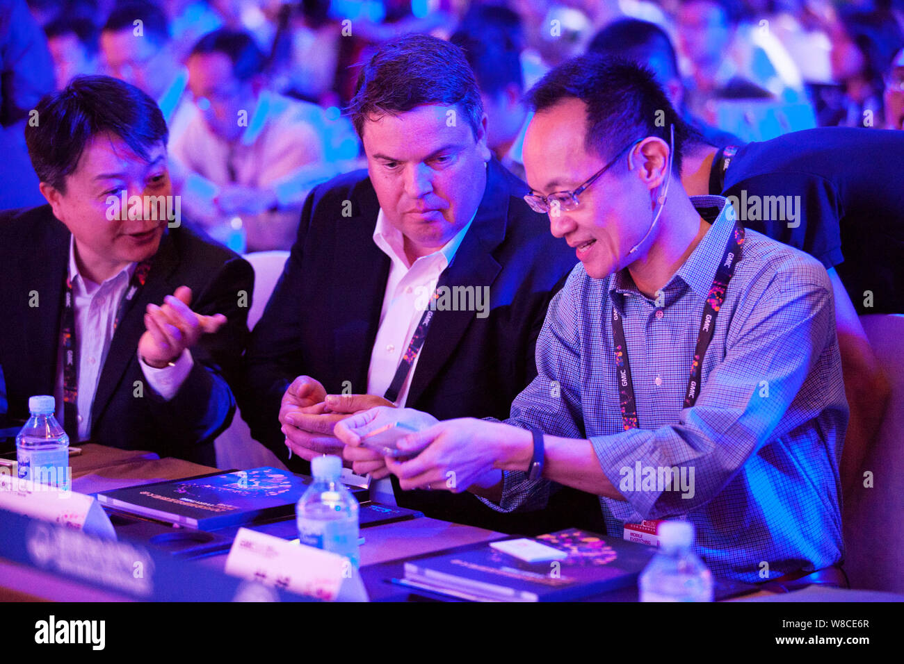 Lin Bin, right, co-founder and president of Xiaomi Corporation, shows the new Xiaomi Note to Matt Grob, center, Executive Vice President and Chief Tec Stock Photo