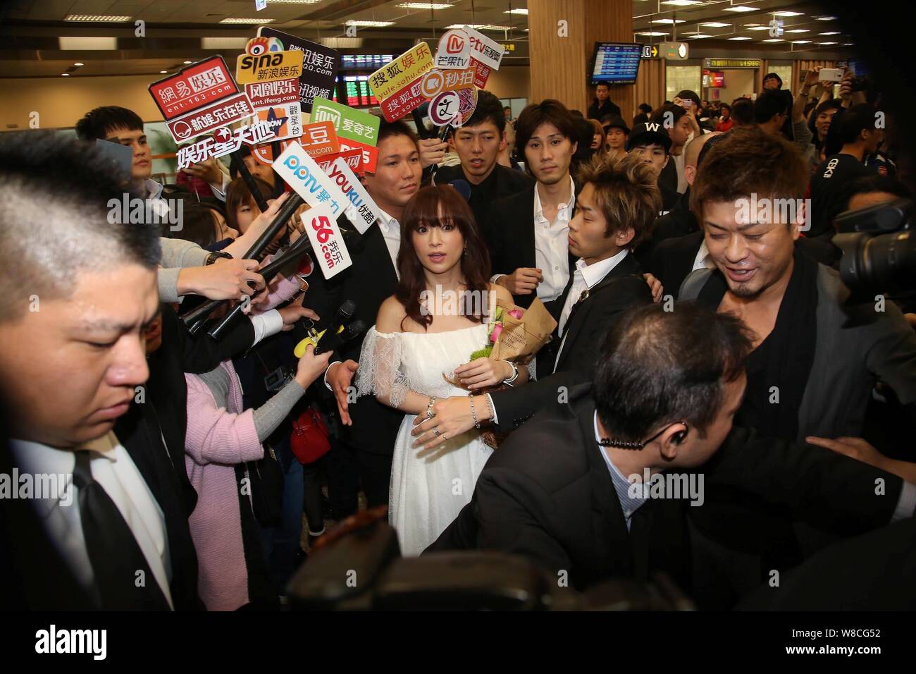 Japanese singer Ayumi Hamasaki, center, is surrounded by reporters at the Taipei Songshan Airport after arriving in Taipei, Taiwan, 14 February 2015. Stock Photo