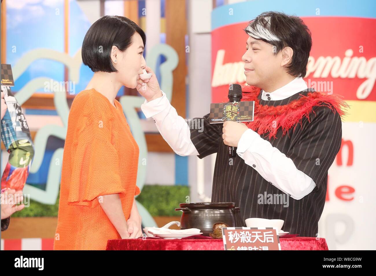 Taiwanese host Kevin Tsai, right, feeds hostess Dee Hsu soup during the