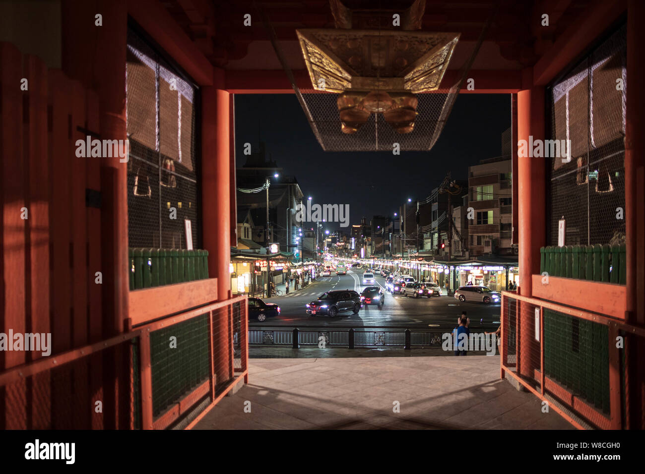 Kyoto, Japan - April 2, 2019: View through temple gate on light traffic moves on main street connecting Gion and Kawaramachi Stock Photo