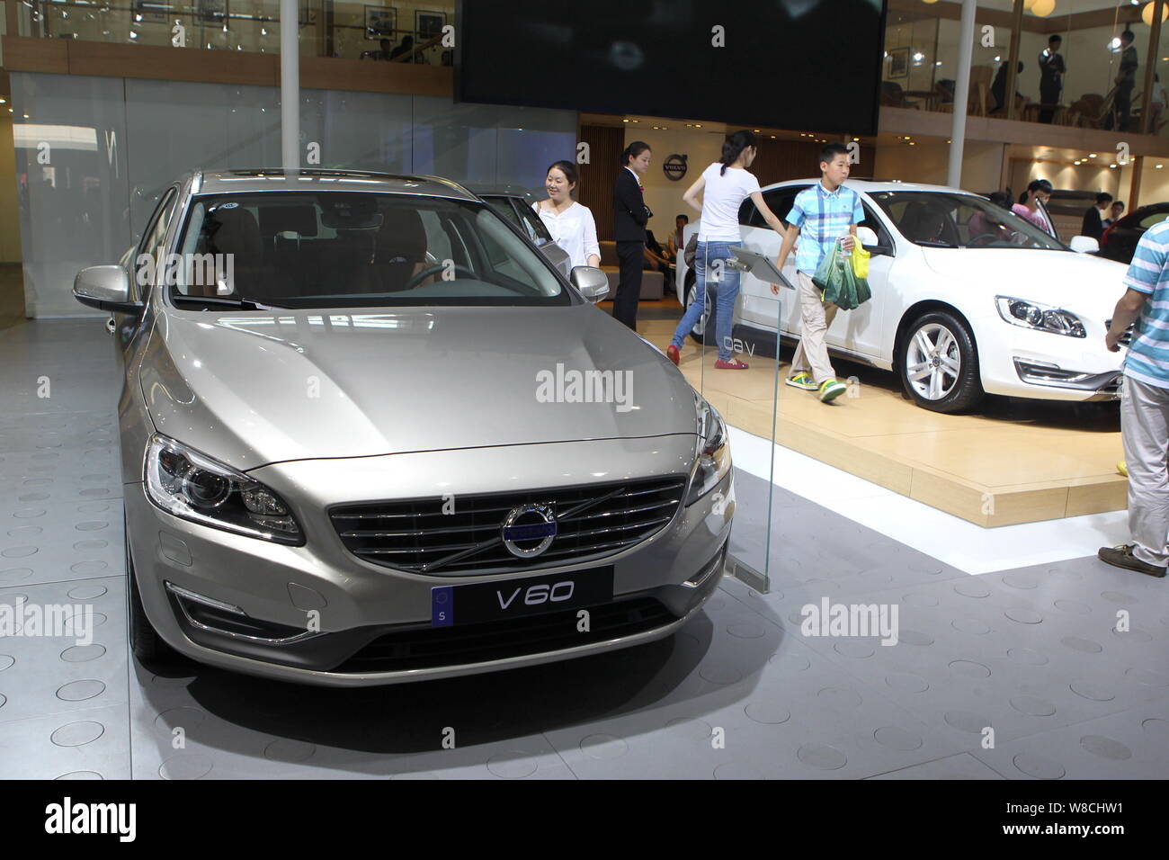 --FILE--Visitors walk past a Volvo V60 during an automobile exhibition in Nanjing city, east China's Jiangsu province, 3 October 2014.   Swedish truck Stock Photo