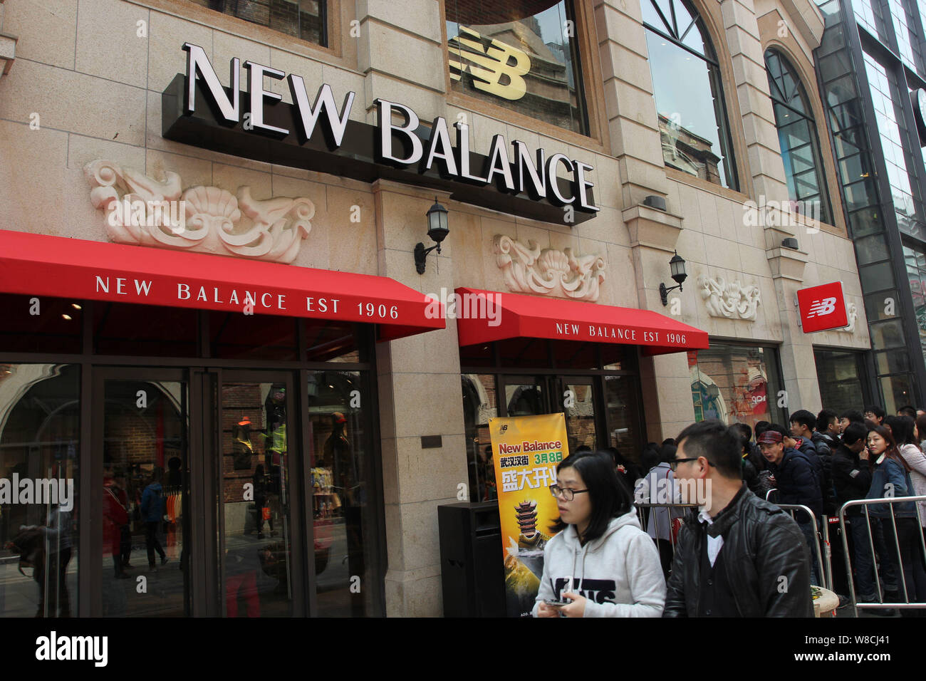 FILE--Pedestrians walk past a sportswear store of New Balance in Wuhan  city, central China's Hubei province, 8 March 2014. US-based sports shoe ma  Stock Photo - Alamy