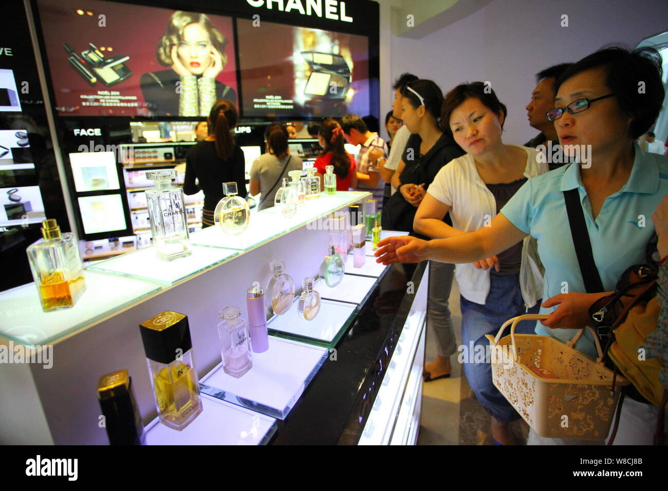 FILE--Customers shop for perfume at a cosmetics store of Chanel in