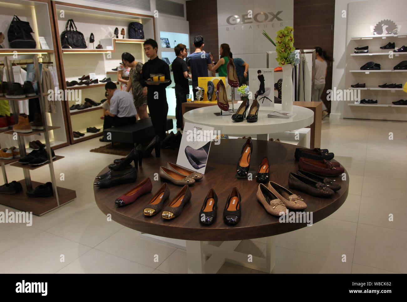 FILE--Customers buy shoes in a store of Italian shoemaker Geox at a  shopping mall in Wuhan city, central China's Hubei province, 31 August  2013. I Stock Photo - Alamy
