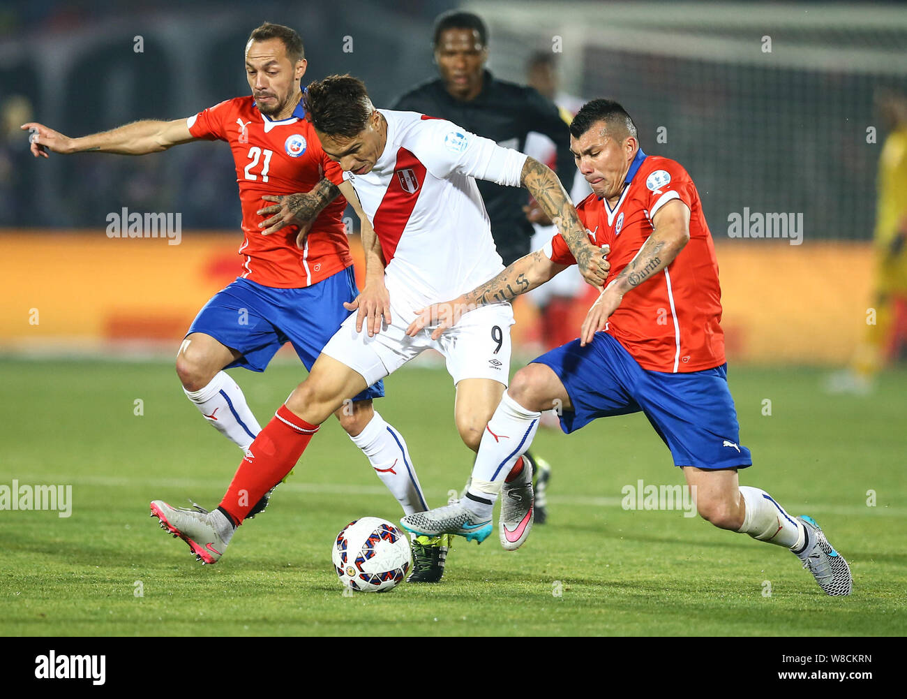 Chile's Marcelo Diaz, left, and Gary Medel, right, challenge Peru's Jose Guerrero, center, during the Copa America 2015 semi-final soccer match betwee Stock Photo