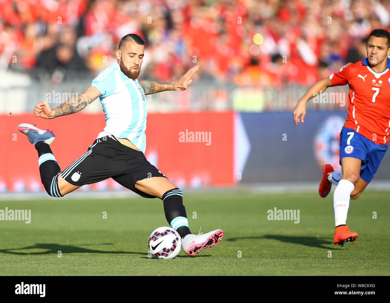 Argentina's Nicolas Otamendi, left, prepares to shoot against Chile during the Copa America 2015 final soccer match between Chile and Argentina at the Stock Photo
