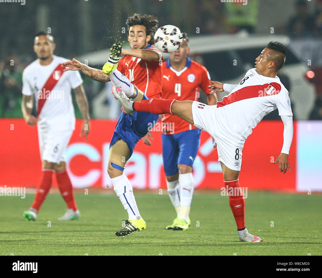 Peru's Michael Guevara, right, challenges Chile's Jorge Valdivia, center, during the Copa America 2015 semi-final soccer match between Chile and Peru Stock Photo