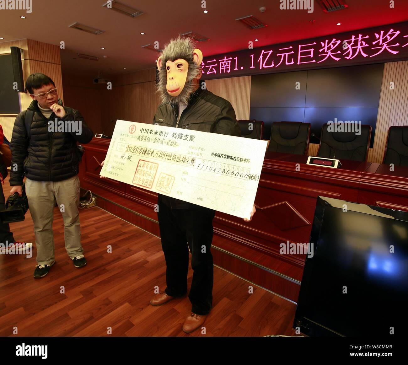 påske Registrering Broom The 110 million yuan ($17 million lottery winner, right, wearing a monkey  face mask poses with his check during a ceremony at a lottery center in  Kunm Stock Photo - Alamy