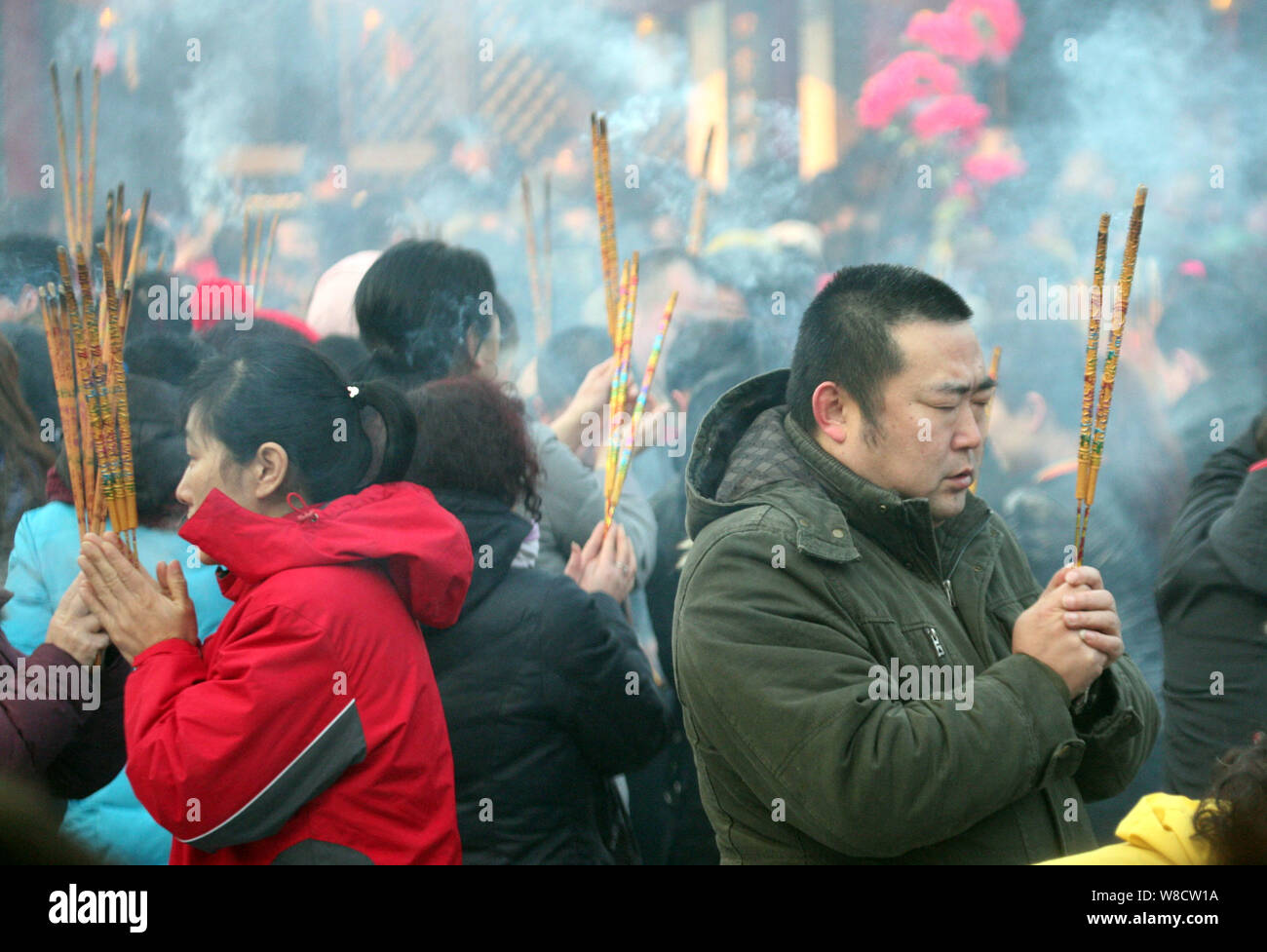 Chinese worshippers burn incense sticks to pray for good fortune and celebrate the Year of the Ram on the first day of Chinese Lunar New Year at Ci'en Stock Photo