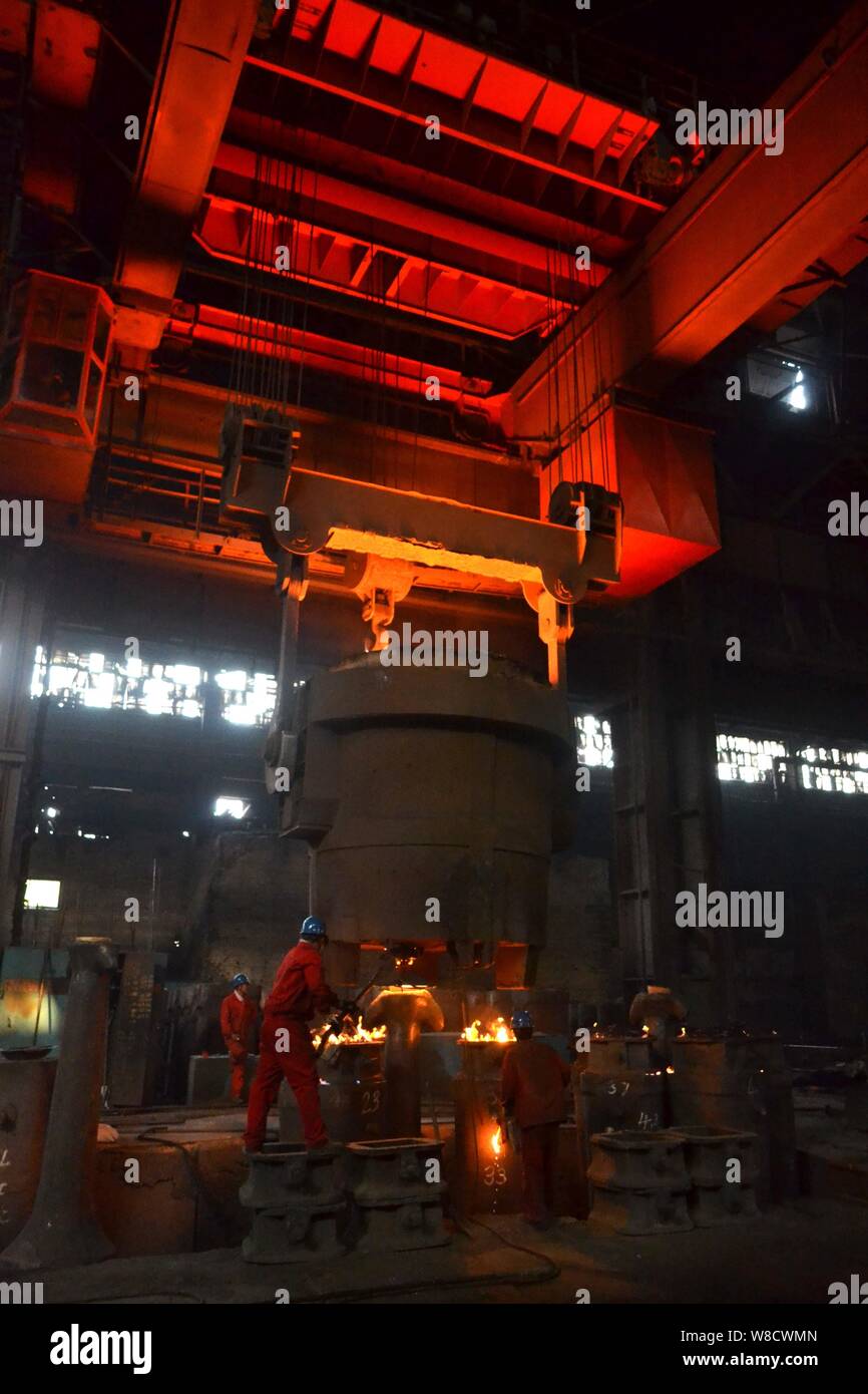 --FILE--Chinese workers survey the production of steel around a furnace containing molten steel at a plant of Dongbei Special steel Group Co., Ltd. in Stock Photo