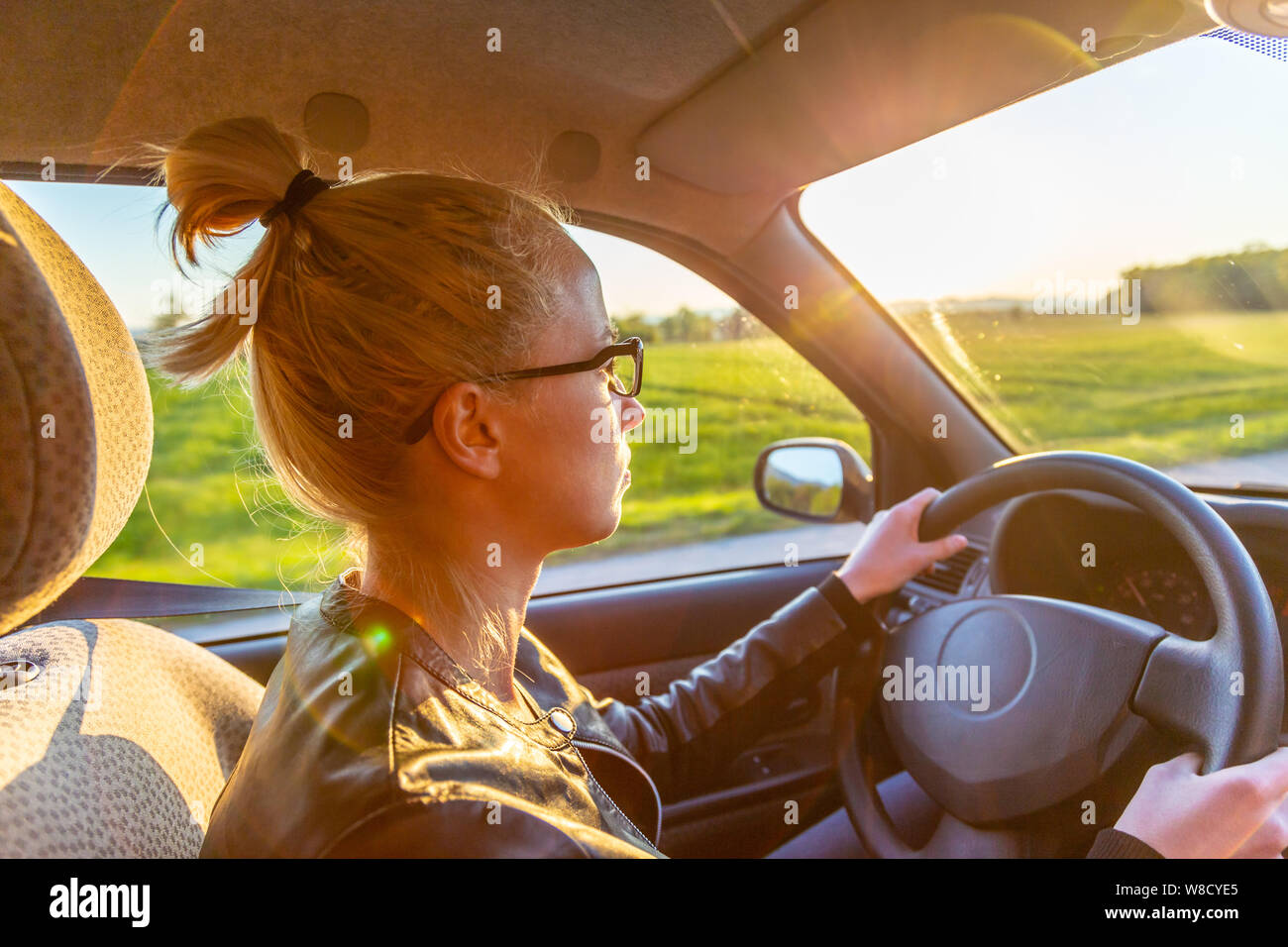 Casual caucasian woman driving passenger car for a journey in countryside. Stock Photo