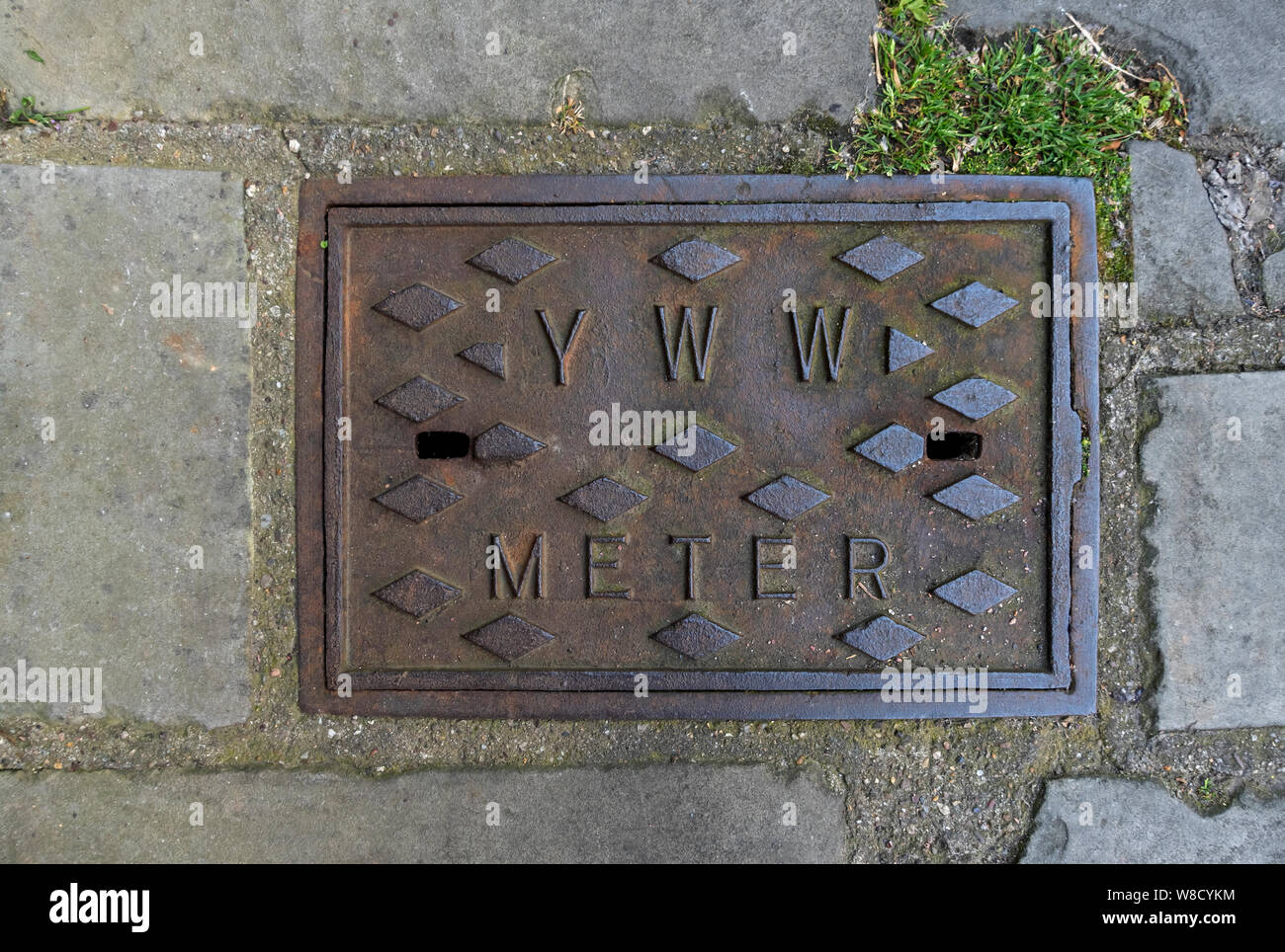 Close up of old cast iron York water works water meter cover outside a house North Yorkshire England UK United Kingdom GB Great Britain Stock Photo
