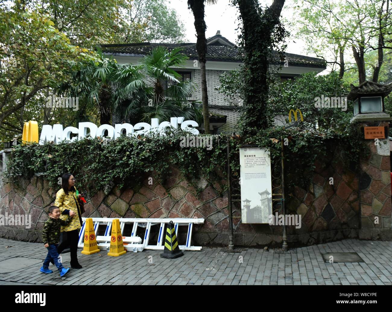 Pedestrians walk past a fastfood restaurant of McDonald's, which was the former Kuomintang leader Chiang Ching-kuo's former residence, in Hangzhou cit Stock Photo