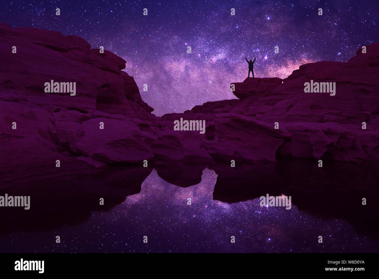 Night landscape with Milky Way. Silhouette of a standing young man with ...