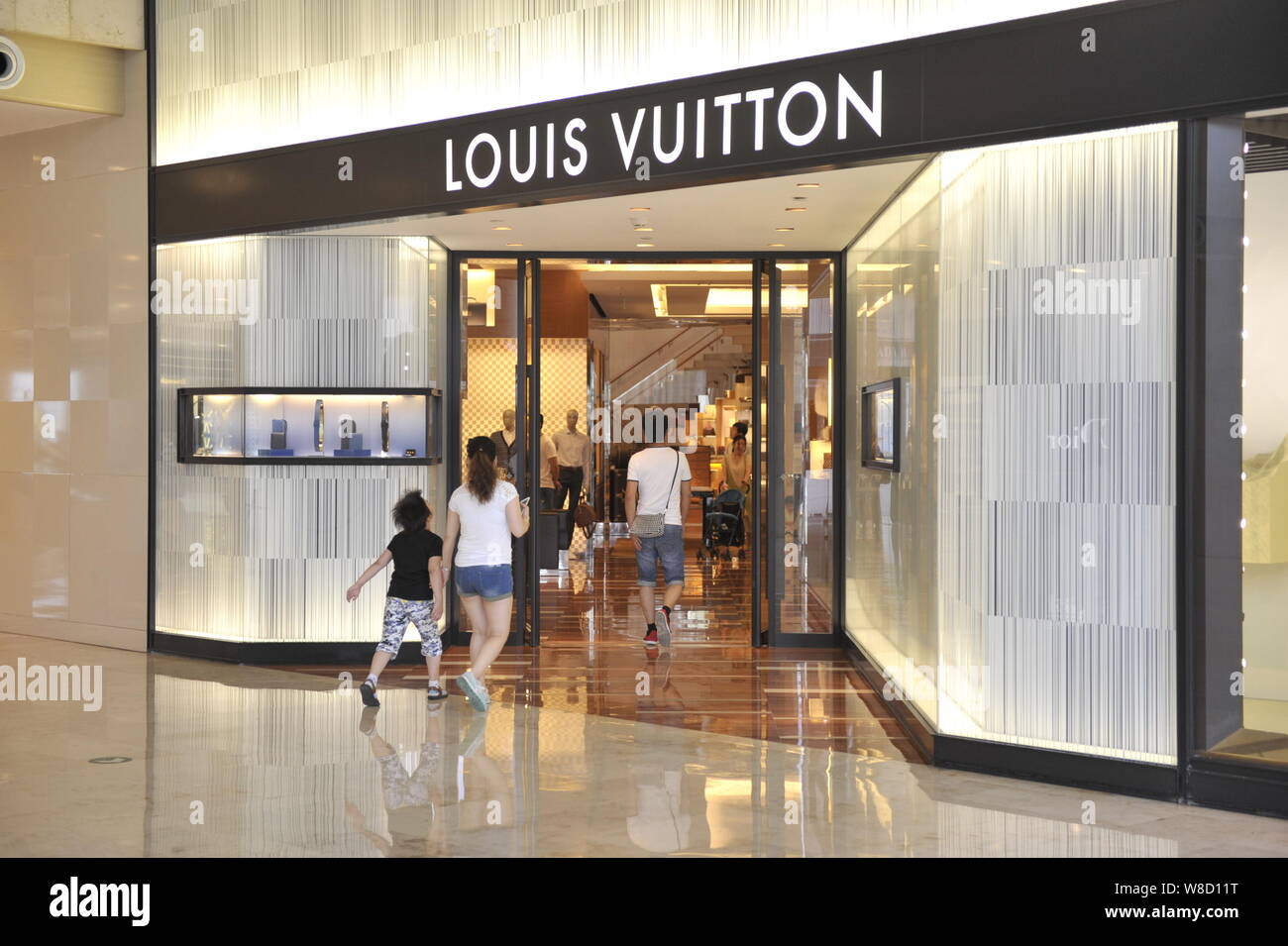 FILE--Shoppers walk past the fashion store of Louis Vuitton (LV) at Deji  Plaza in Nanjing city, east Chinas Jiangsu province, 9 September 2013. Lu  Stock Photo - Alamy