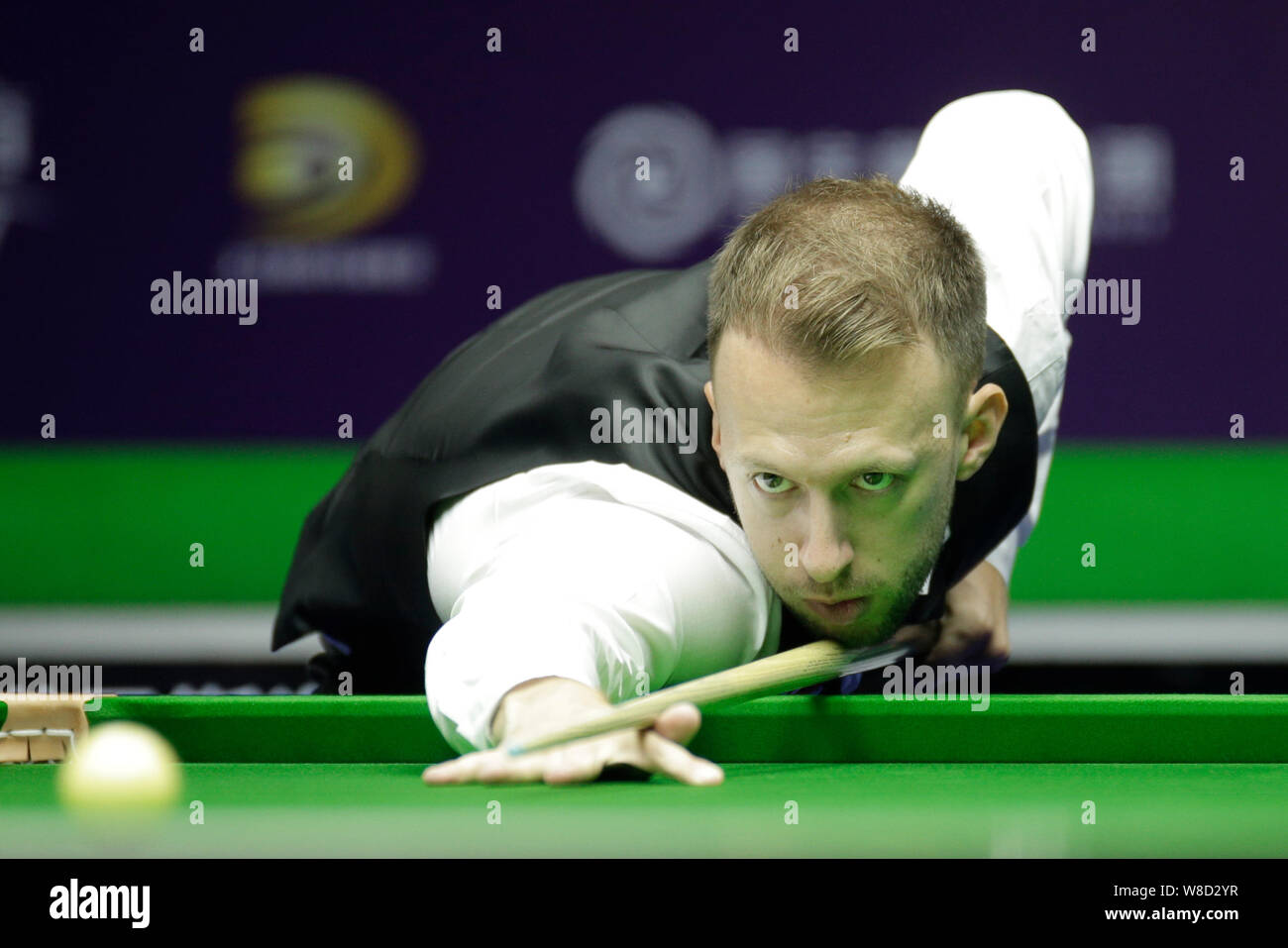 Judd Trump of England plays a shot to Tom Ford of England their match