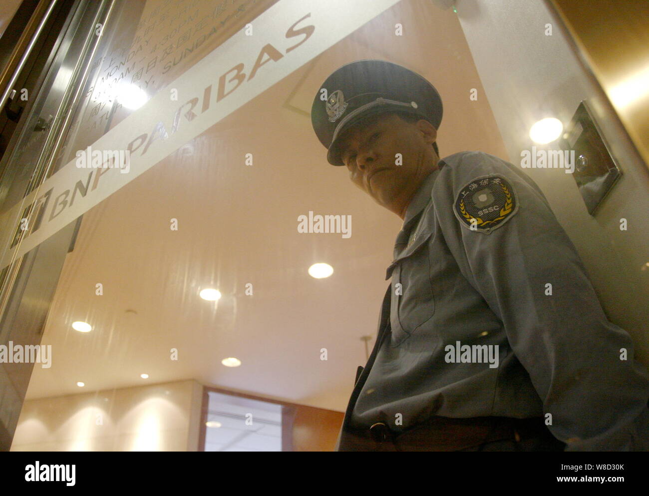 --FILE--A Chinese security guard stands at the office of BNP Paribas in the Lujiazui Financial District in Pudong, Shanghai, China, 21 September 2009. Stock Photo