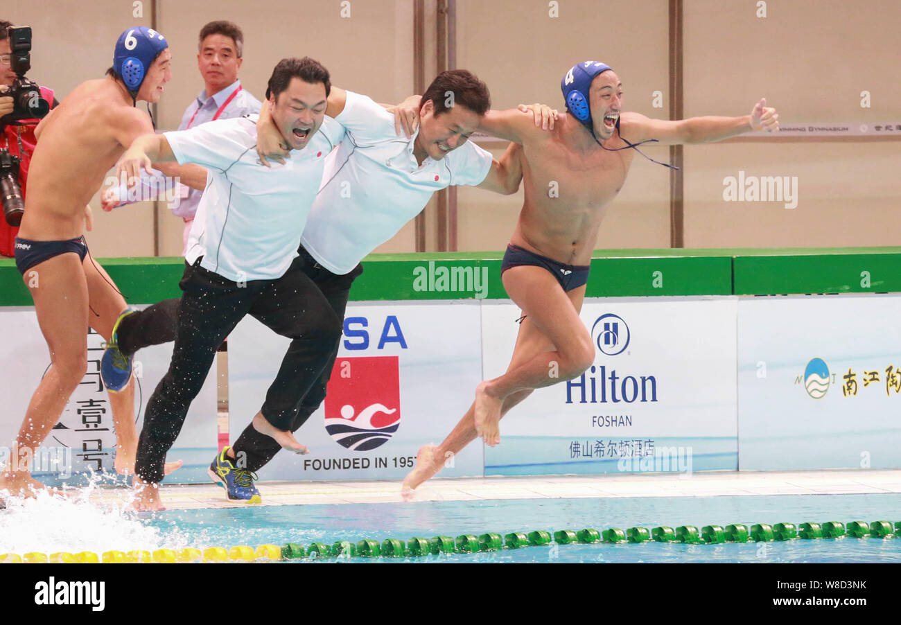 Coaches and players of Japan men's national water polo team celebrate after defeating China men