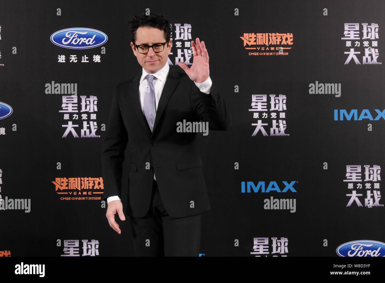American director J. J. Abrams waves during a premiere for his movie 'Star Wars: The Force Awakens' in Shanghai, China, 27 December 2015. Stock Photo